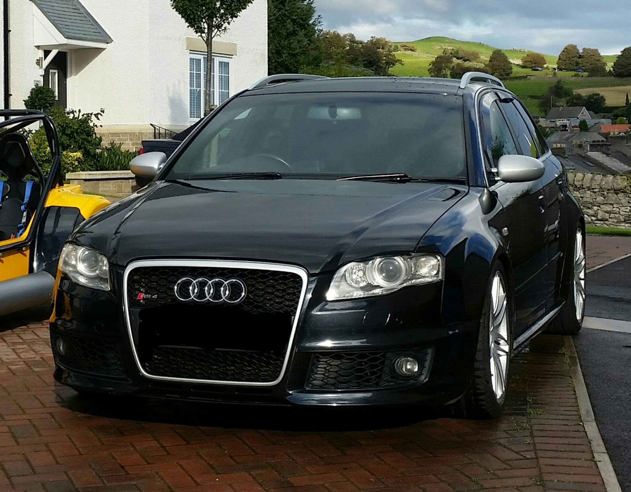 Black Audi RS4 Avant on a driveway with the fells behind